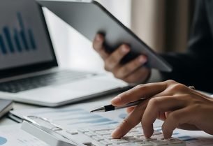 Financial analyst calculating data with calculator tablet and la