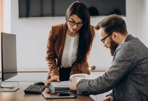 Two business partners working together in office on computer