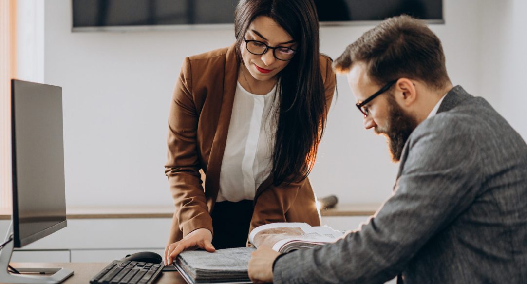 Two business partners working together in office on computer
